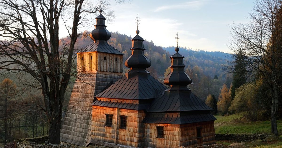 A historic wooden church in Dubne, Poland, at sunset
