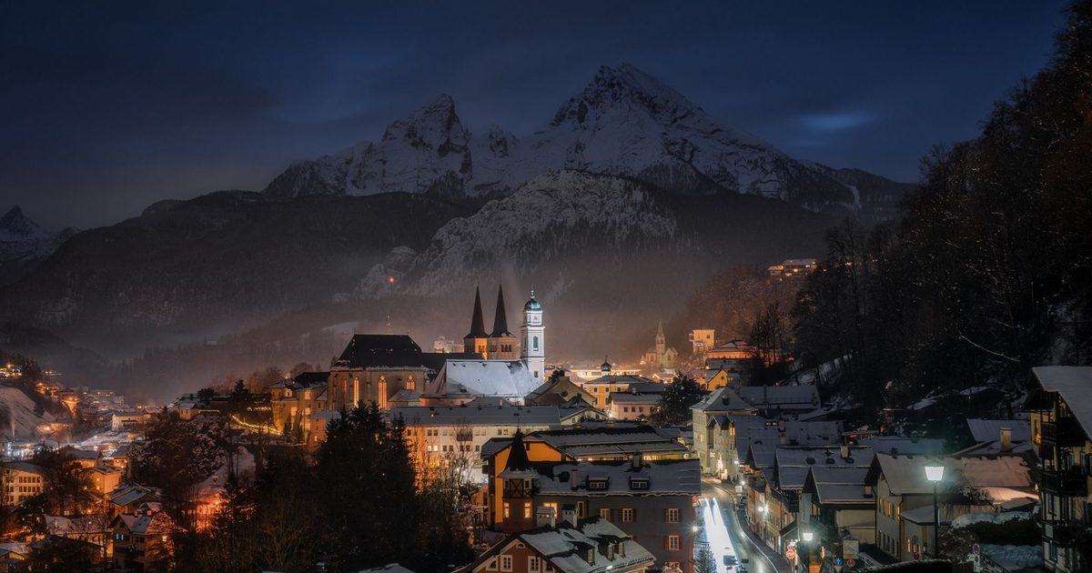Berchtesgaden, Germany, on a winter night, with snow-covered rooftops and mountains
