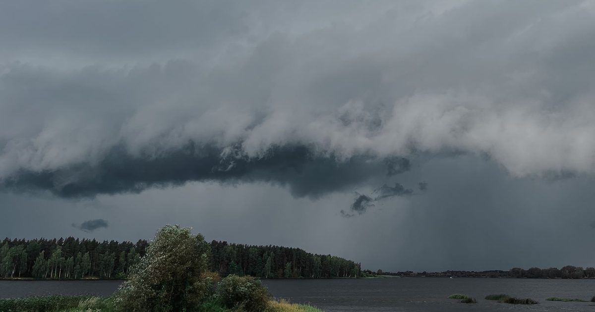 A storm cloud over a lake and forest
