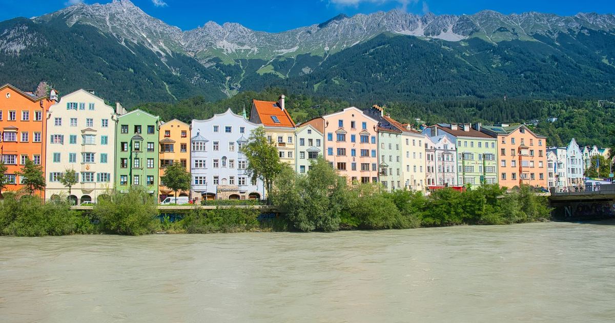 Brightly coloured houses along the river in Innsbruck, below the mountains