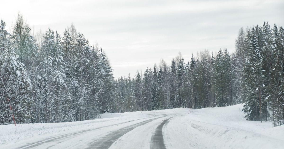 A winter road through a snowy forest in Rovaniemi, Lapland