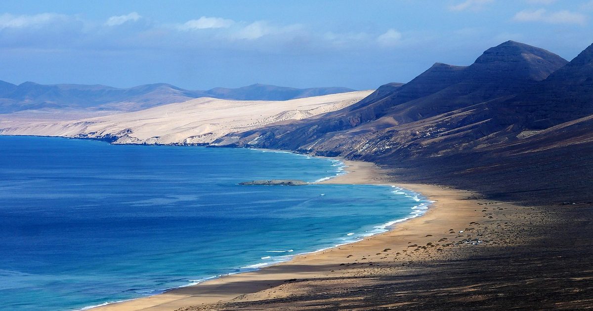 A beach below mountains in the Canary Islands
